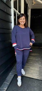 Woman in a navy tracksuit standing outside a building