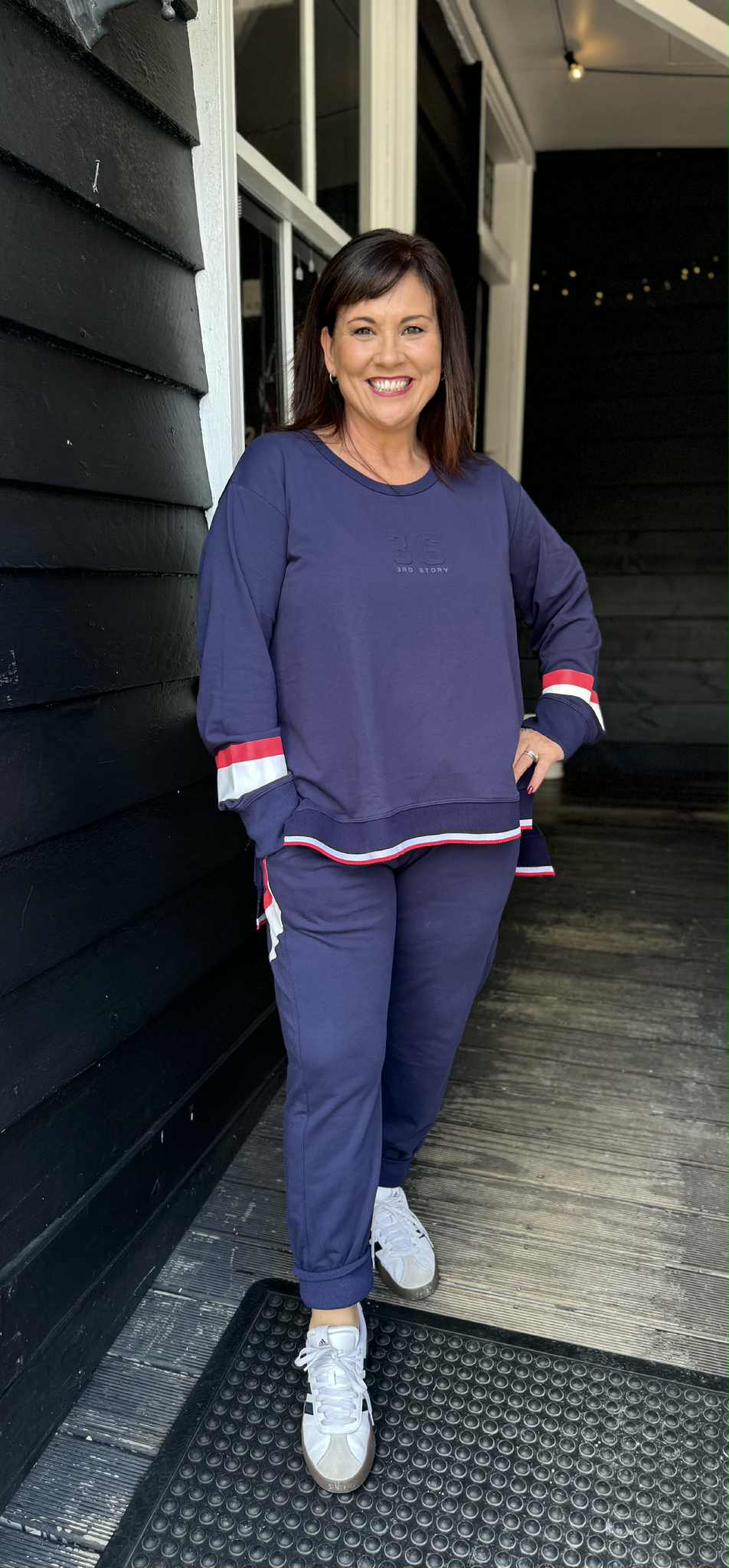 Woman in a navy tracksuit standing outside a building